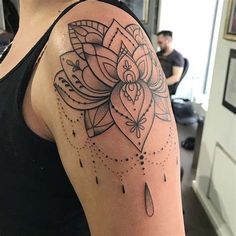 a woman with a tattoo on her arm has a black and white flower in the center