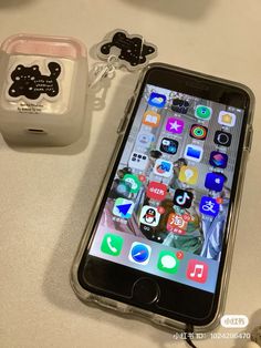 an iphone with hello kitty stickers on it next to a charger and keychain