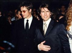 two men in suits and sunglasses standing next to each other