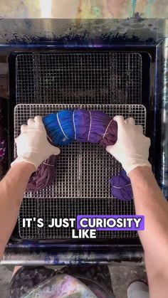 a person with their hands on top of a metal rack that has some purple and blue items in it