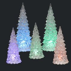 three small christmas trees are lit up with colored lights