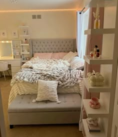 a bed room with a neatly made bed and some shelves on the wall next to it