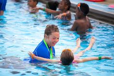 several children in a swimming pool playing with each other