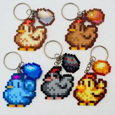 six pixel keychains with different types of characters on them, all in various colors and sizes