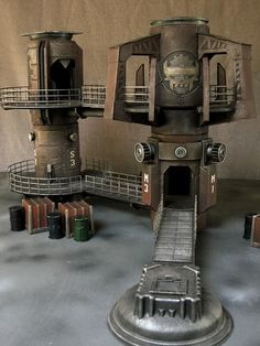 there is a model of an old clock tower on the floor with other items around it