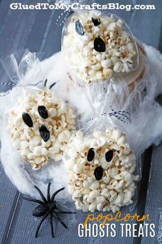 three halloween popcorn treats in bags on top of a table