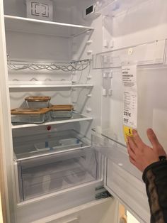 a person is looking into an empty refrigerator