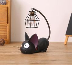 a black cat lamp sitting on top of a wooden table