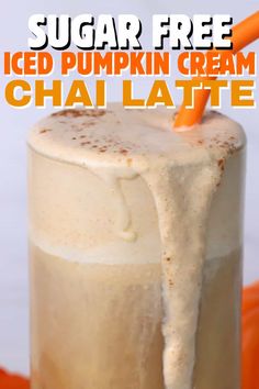 an iced pumpkin cream chai latte in a tall glass with a carrot sticking out of it