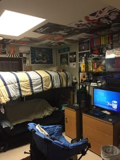 a dorm room with bunk beds, desk and television