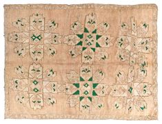 an old rug with green and white designs on it's edges, in the shape of flowers