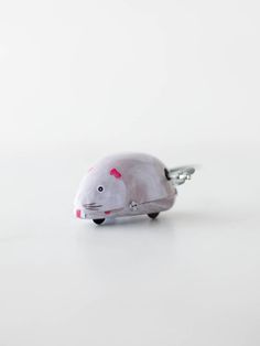 a white mouse keychain with pink hearts on it