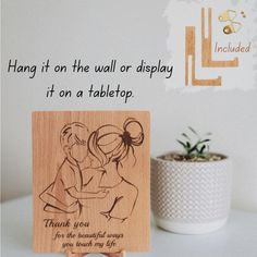 a wooden plaque with an image of two people on it and the words, hang it on the wall or display it on a tabletop