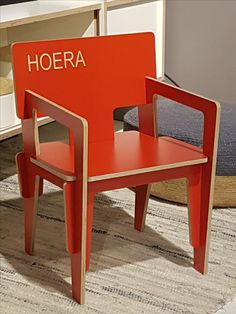 a red wooden chair sitting on top of a rug