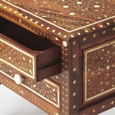 an intricately decorated wooden box with drawers