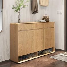 a wooden cabinet with shoes on it in front of a mirror and coat rack hanging on the wall