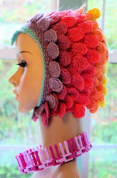 a mannequin head wearing a crocheted hat and pink hair combs