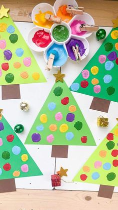 christmas tree craft made with construction paper and colored glue on a white board surrounded by other crafts