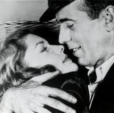 a black and white photo of a man kissing a woman