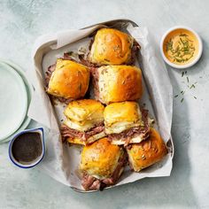 a tray filled with pastries next to a bowl of dipping sauce