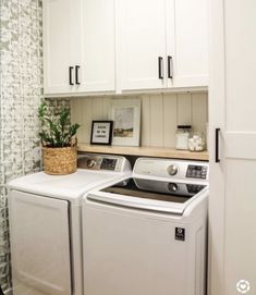 a white washer and dryer in a small laundry room with green wallpaper