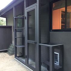 a dog kennel is shown with its doors open and the door to the outside