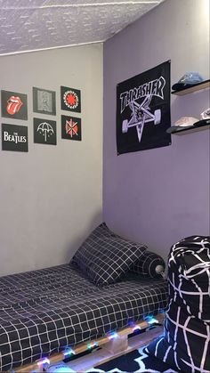 a bedroom with purple walls and black bedspread, lights on the bottom bed