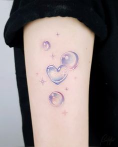 a woman's arm with two hearts and stars on the left side of her body