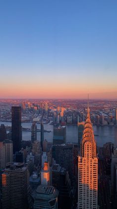 an aerial view of new york city at sunset with the empire building in the foreground