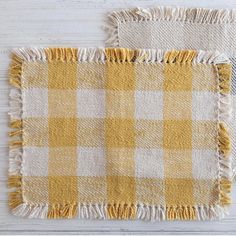 two yellow and white checkered rugs on top of a wooden floor next to each other