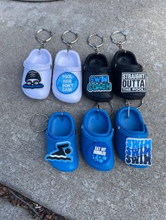 several pairs of baby shoes are on the ground with keychains attached to them