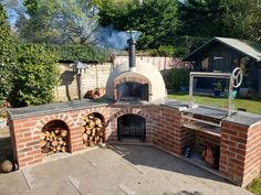 an outdoor brick pizza oven with wood logs