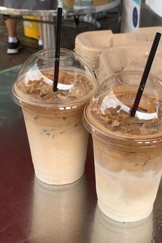 two plastic cups filled with food sitting on top of a table next to each other