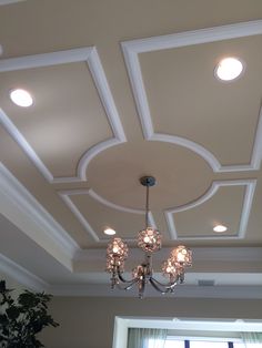 a chandelier hanging from the ceiling in a room with white walls and ceilings