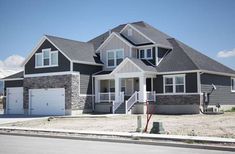 a large gray and white house with two garages