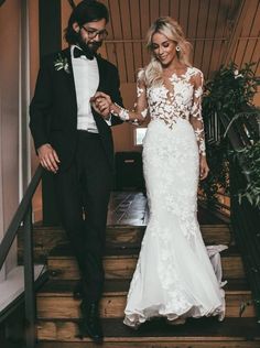 the bride and groom are walking down the stairs