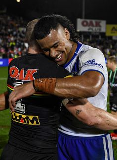 two rugby players hugging each other on the field