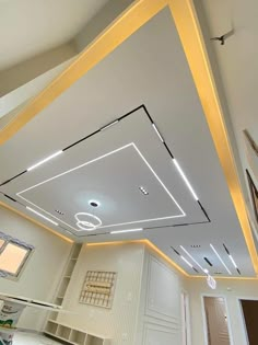 an empty room with white walls and gold trimmings on the ceiling is lit by recessed lights