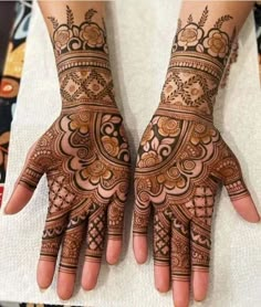 two hands with henna tattoos on them