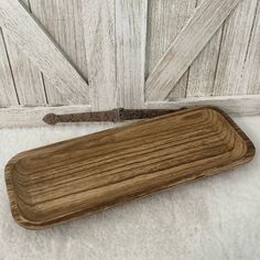 a wooden tray sitting on top of a white blanket