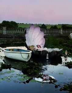 there is a boat in the water with a large flower on it's back