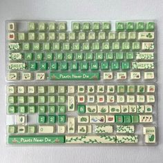 a green and white computer keyboard sitting on top of a table covered in magnets