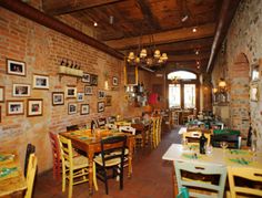 the interior of a restaurant with tables and chairs set up in rows on brick walls