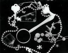 a black and white photo with beads, necklaces and other items on it's surface