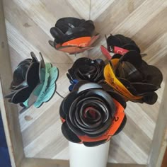 there is a vase with many shoes in it on the floor next to a wall