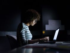 a woman sitting in front of a laptop computer