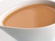 a white bowl filled with liquid sitting on top of a table