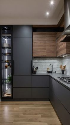 a modern kitchen with wood flooring and stainless steel appliances in the cabinets, along with wooden floors