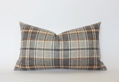 a gray and brown plaid pillow on a white background