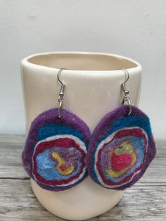 the earrings are made from wool and have colorful circles on them